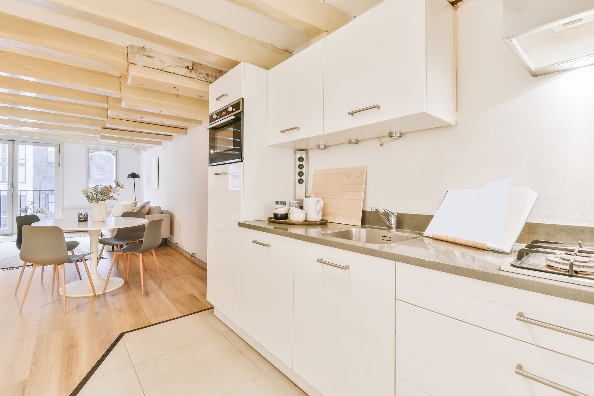 A kitchen featuring a sink, stove, and dining table, showcasing a functional and inviting cooking space.