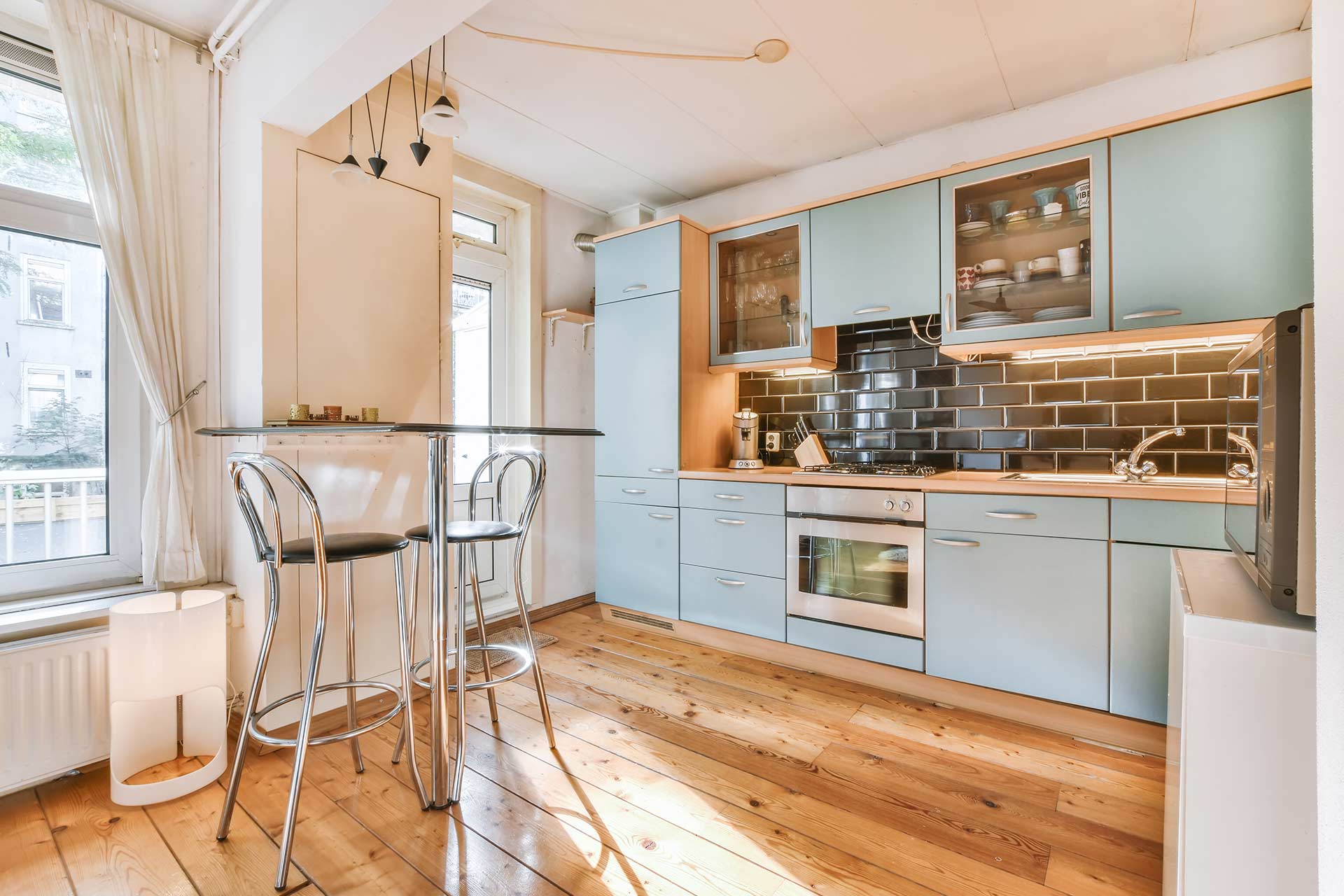 A modern kitchen featuring blue cabinets and a stylish bar stool for seating.