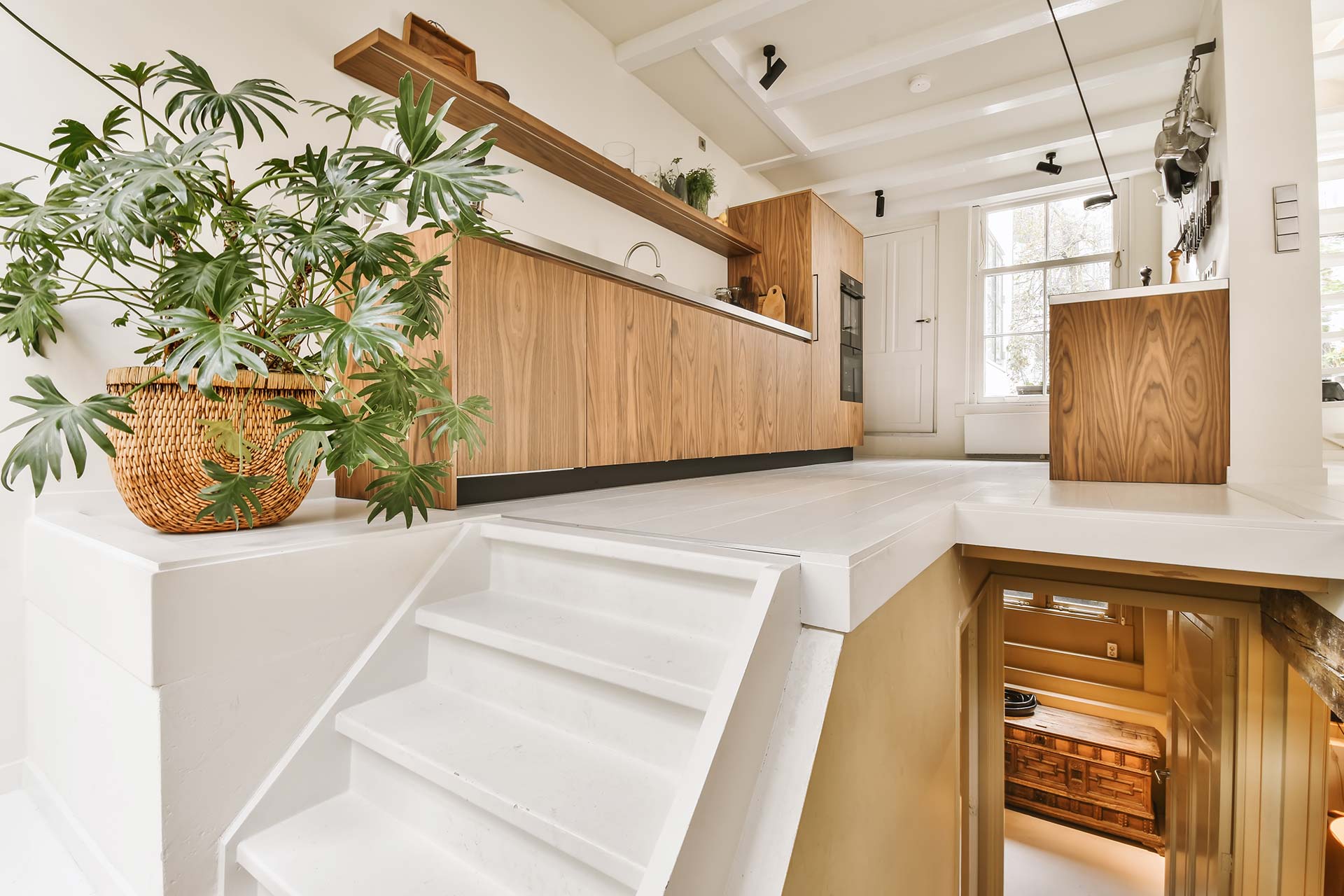 A kitchen with a staircase ascending to the living room, highlighting the home's multi-level design and layout.