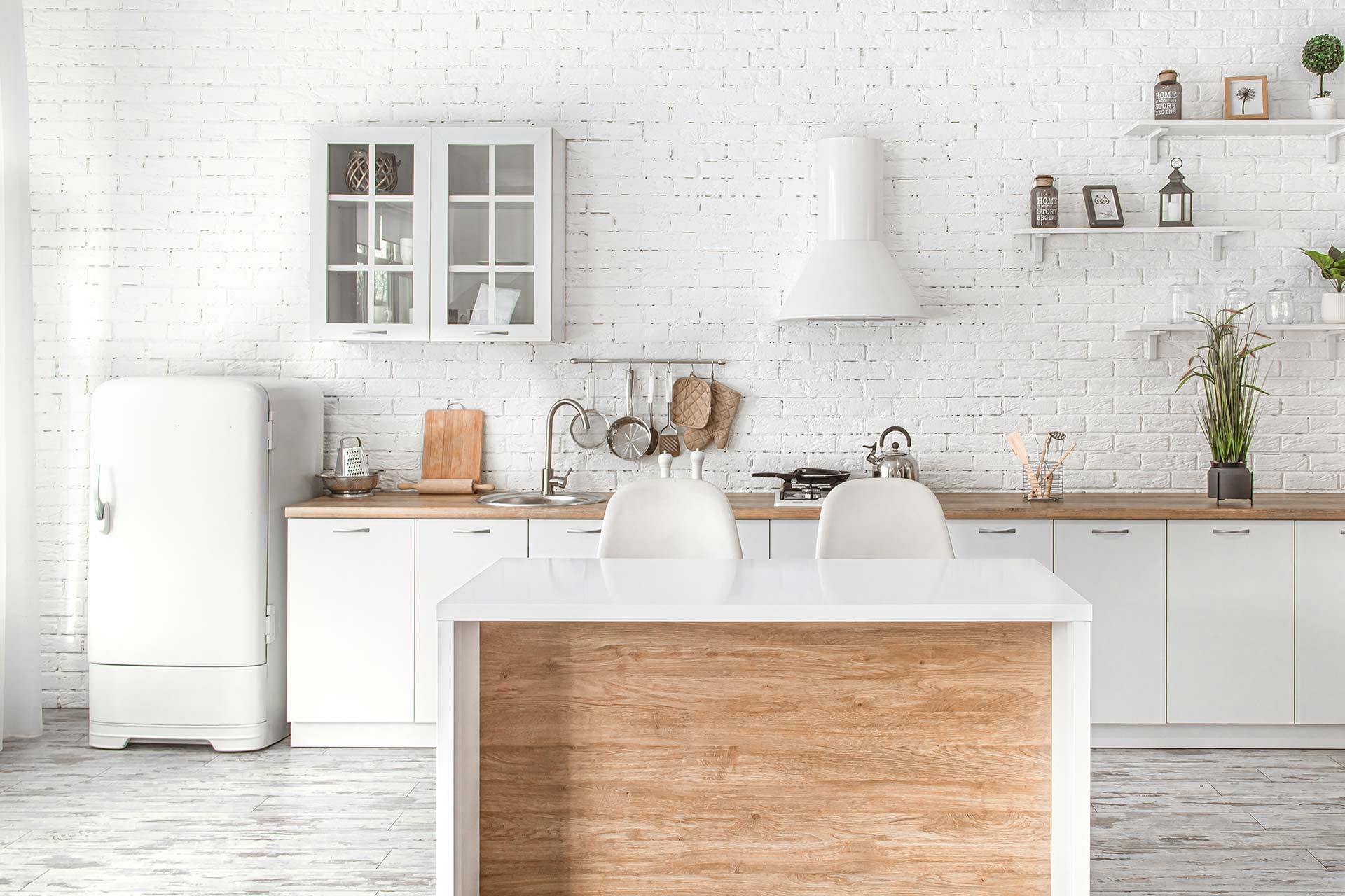 A bright white kitchen featuring a wooden island and clean white walls, creating a modern and inviting atmosphere.