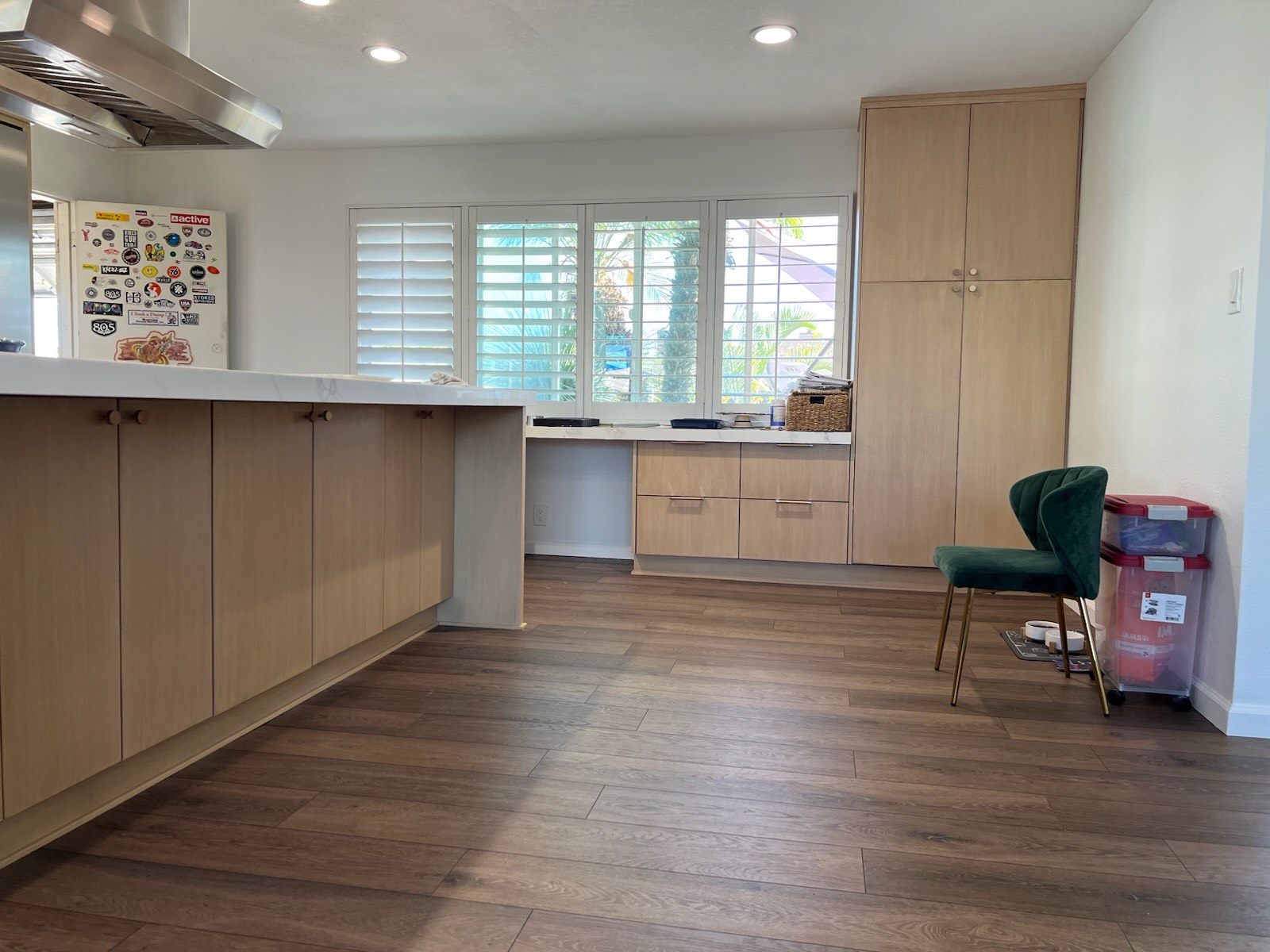 A kitchen featuring wooden floors and a sleek white countertop, creating a bright and inviting atmosphere.