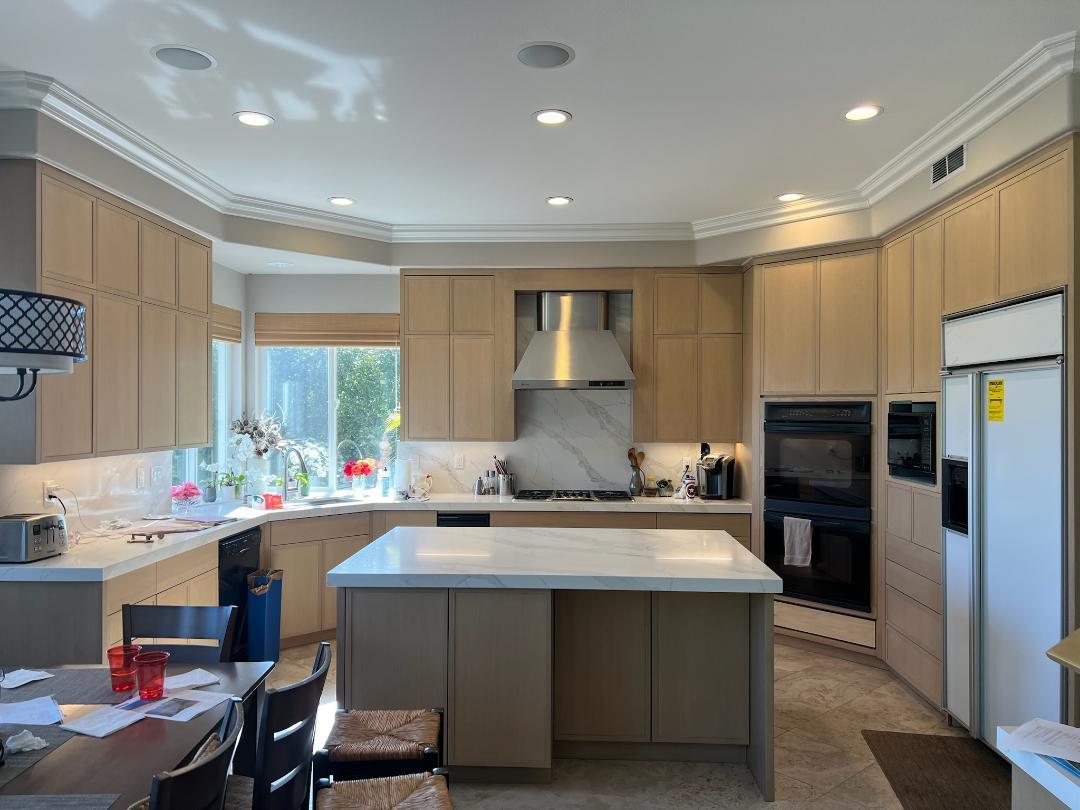 A modern kitchen featuring a central island and a stove, designed for cooking and meal preparation.