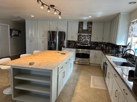 A modern kitchen featuring a large island and sleek white cabinets, creating a bright and spacious cooking area.