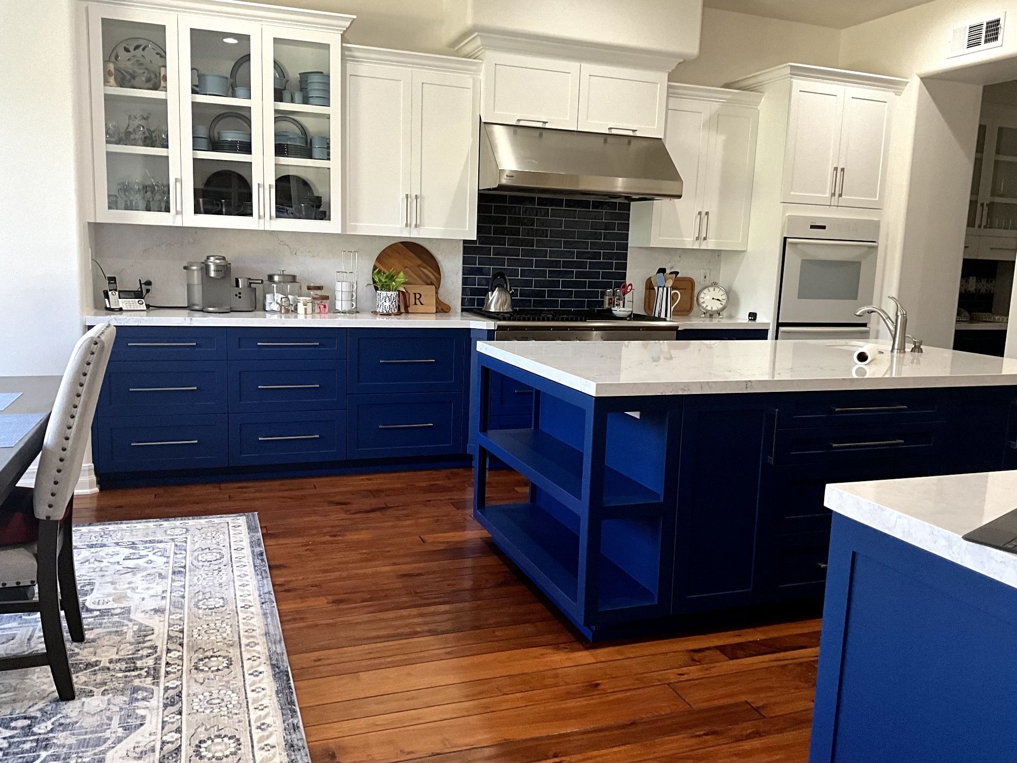 A modern kitchen featuring blue cabinets and white countertops, creating a bright and inviting atmosphere.