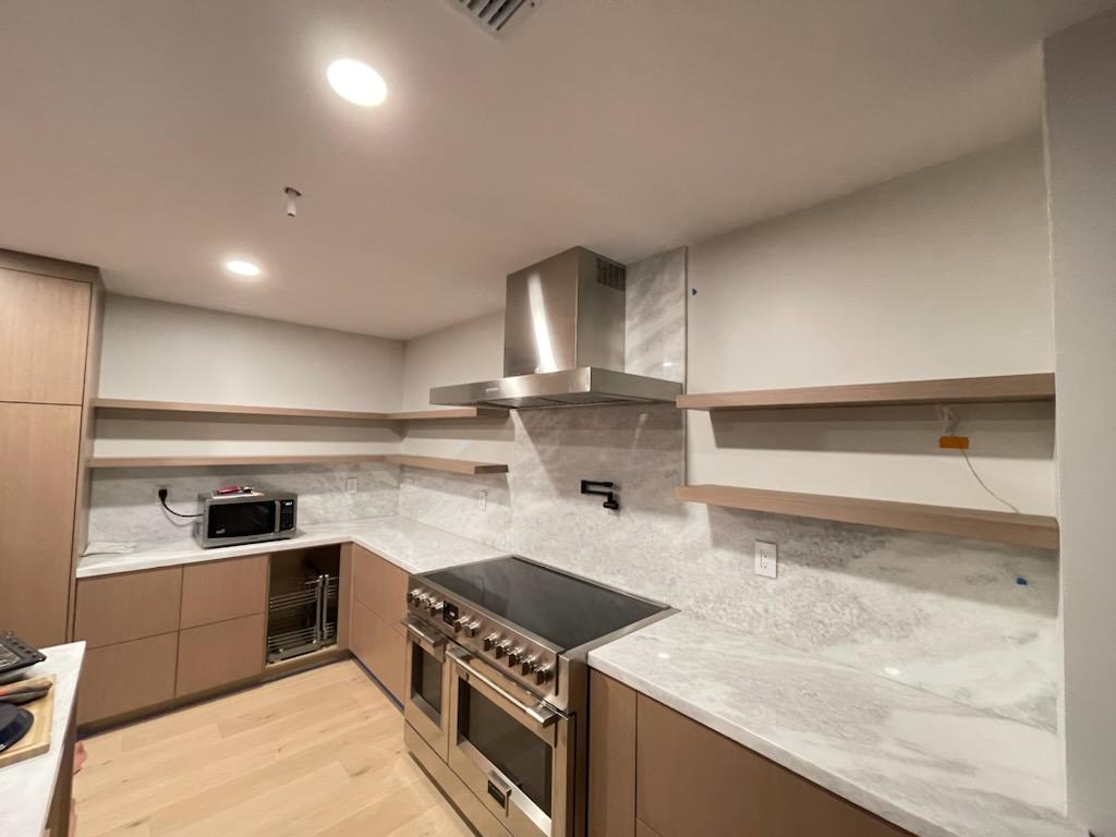 A modern kitchen featuring stainless steel appliances and elegant wood cabinets.